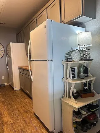 a kitchen with a refrigerator a stove and wooden floor