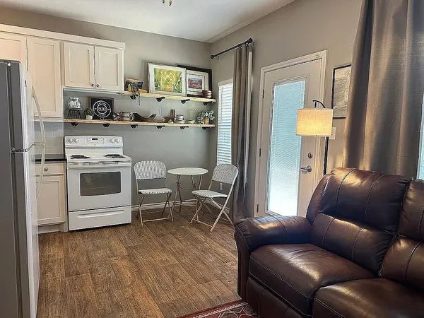 a living room with stainless steel appliances furniture and a window