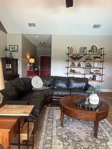 a living room with furniture and wooden floor