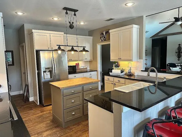 a kitchen with a refrigerator a sink and wooden cabinets