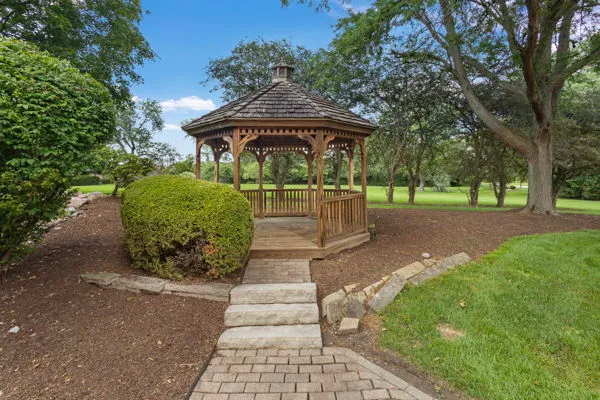 a view of a house with a big yard and large trees