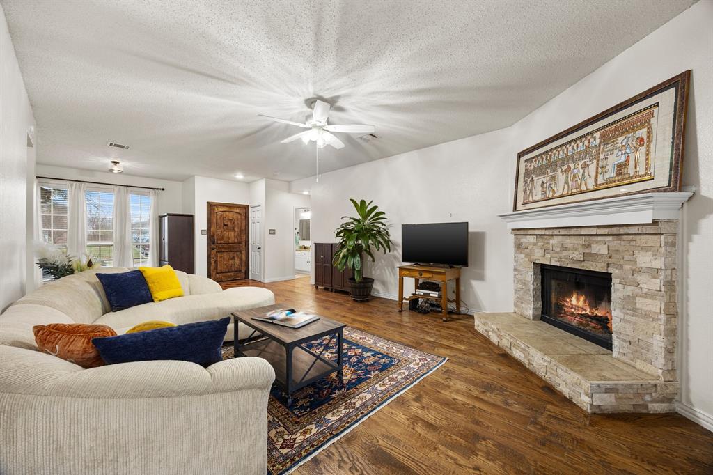 7210 Mercurys Road Rowlett, TX 75089 - Photo 10 of 26 a living room with furniture a flat screen tv and a fireplace