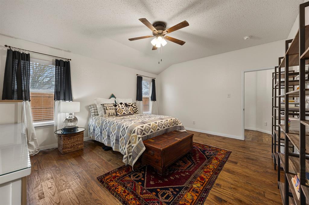 7210 Mercurys Road Rowlett, TX 75089 - Photo 12 of 26 a spacious bedroom with a bed and wooden floor