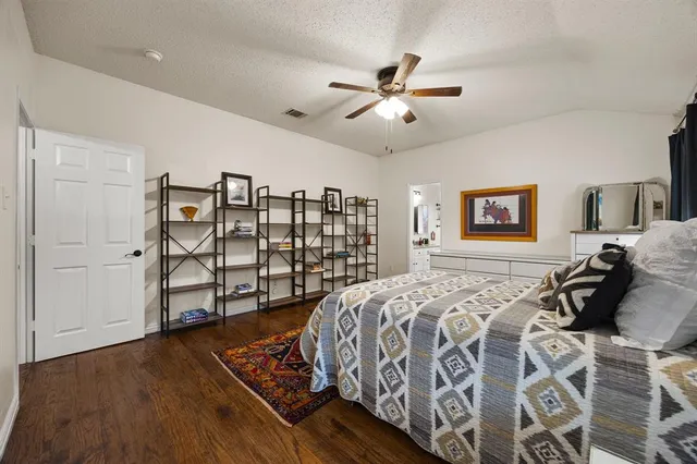 a spacious bedroom with a bed and wooden floor