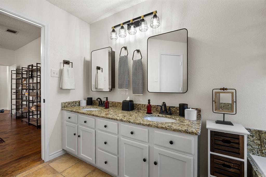 7210 Mercurys Road Rowlett, TX 75089 - Photo 18 of 26 a bathroom with double vanity sinks and a mirror