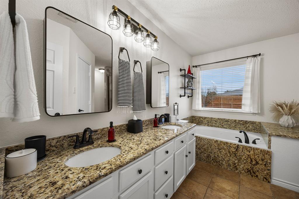 7210 Mercurys Road Rowlett, TX 75089 - Photo 19 of 26 a bathroom with a granite countertop tub sink and mirror
