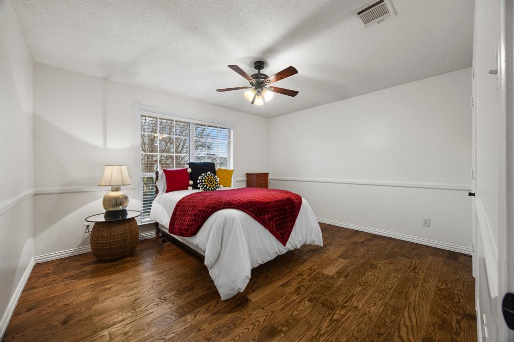 7210 Mercurys Road Rowlett, TX 75089 - Photo 20 of 26 a bed room with a bed and a chandelier
