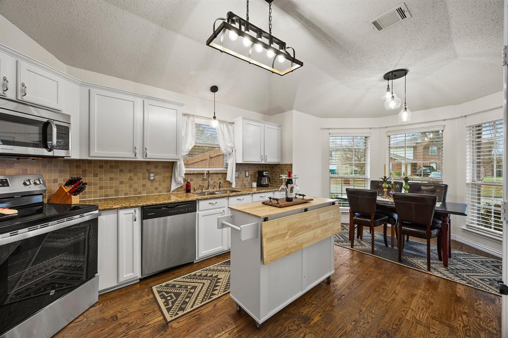 7210 Mercurys Road Rowlett, TX 75089 - Photo 5 of 26 a kitchen with a stove cabinets and chairs