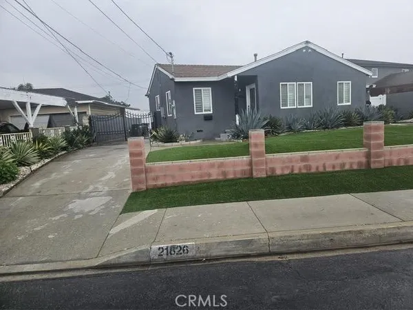 a front view of a house with a garden and plants