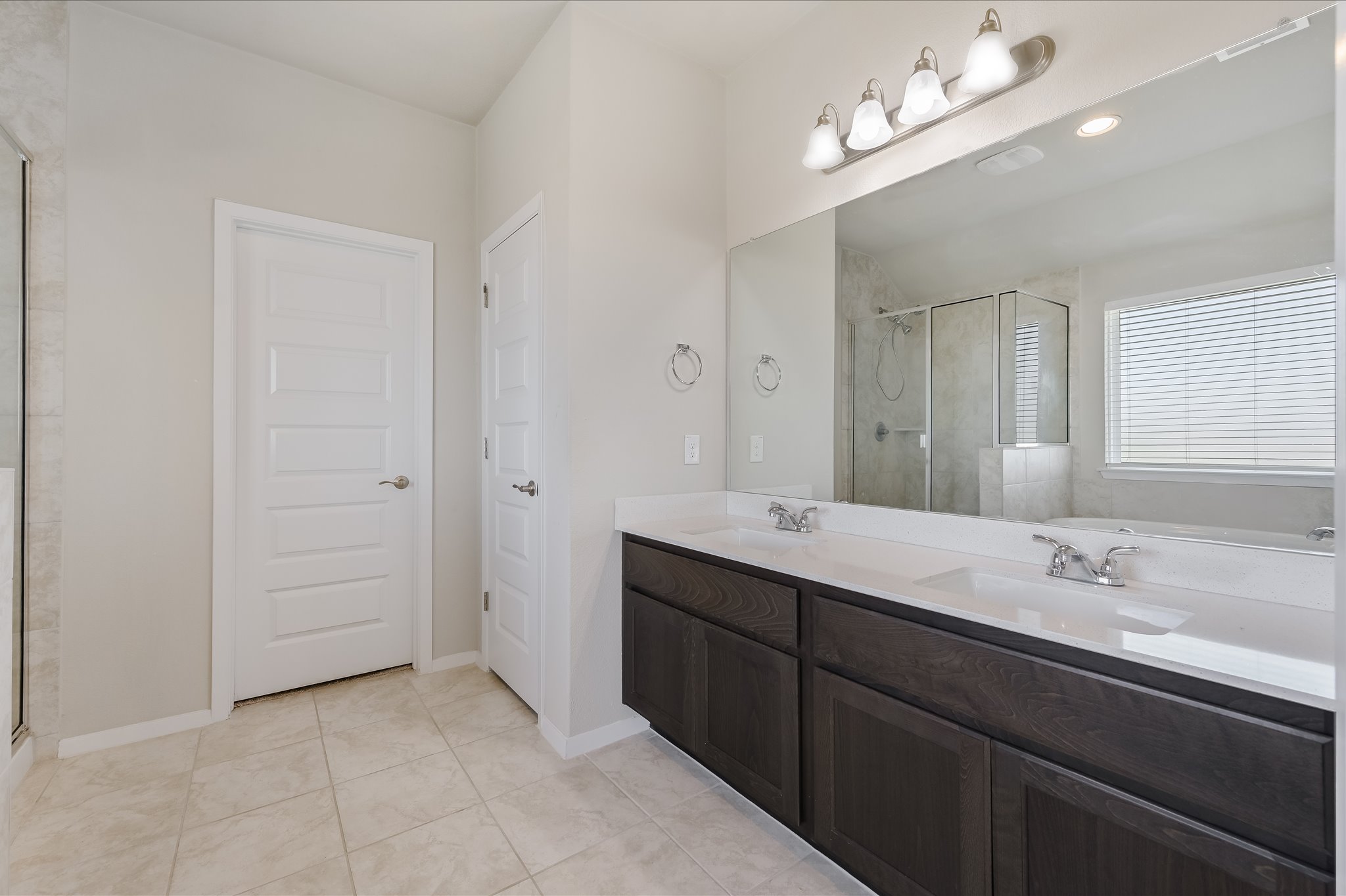201 Spiny Lizard Lane San Marcos, TX 78666 - Photo 11 of 20 a bathroom with a double vanity sink a large mirror and shower