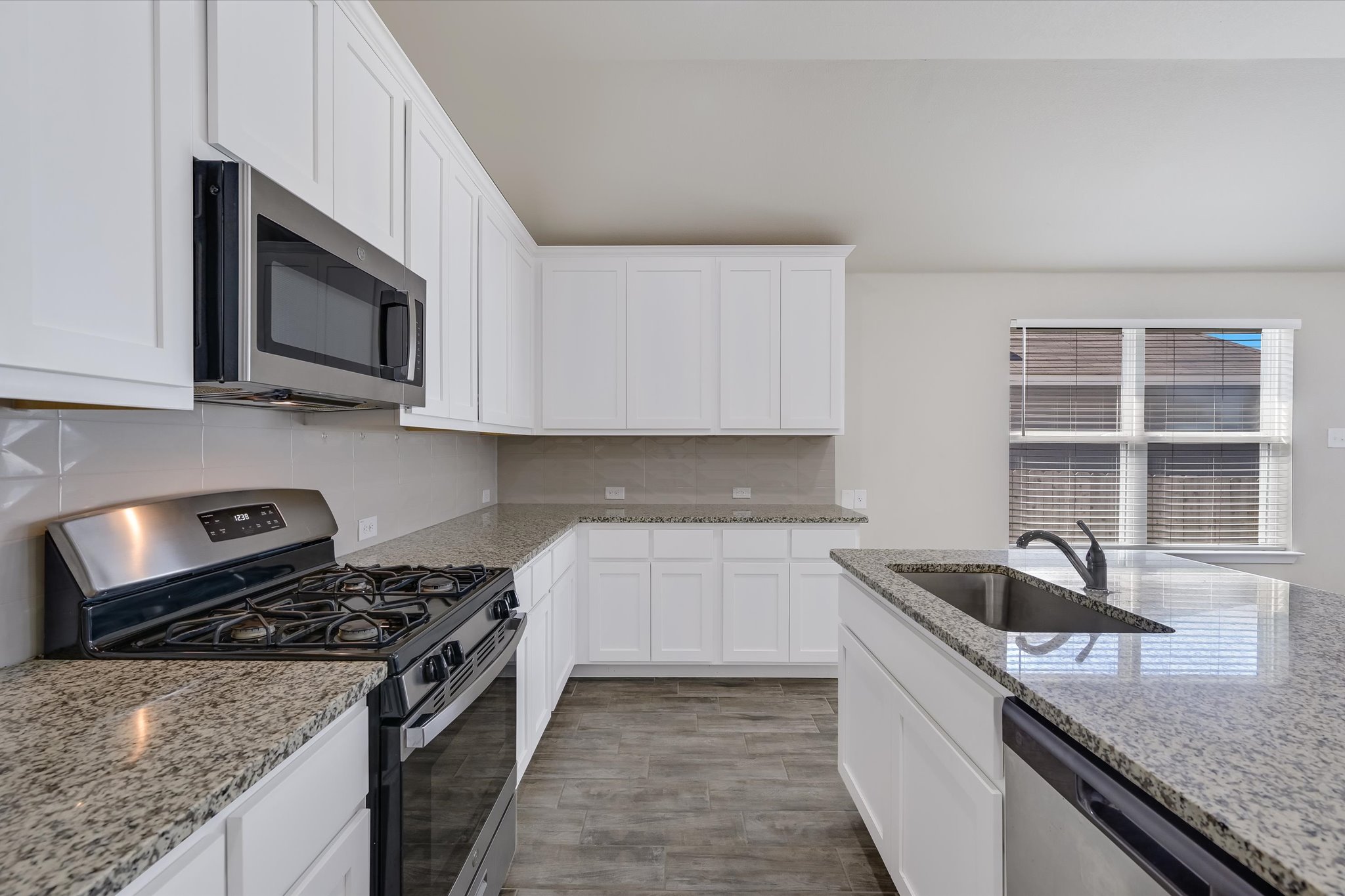 201 Spiny Lizard Lane San Marcos, TX 78666 - Photo 3 of 20 a kitchen with stainless steel appliances granite countertop a sink stove and microwave