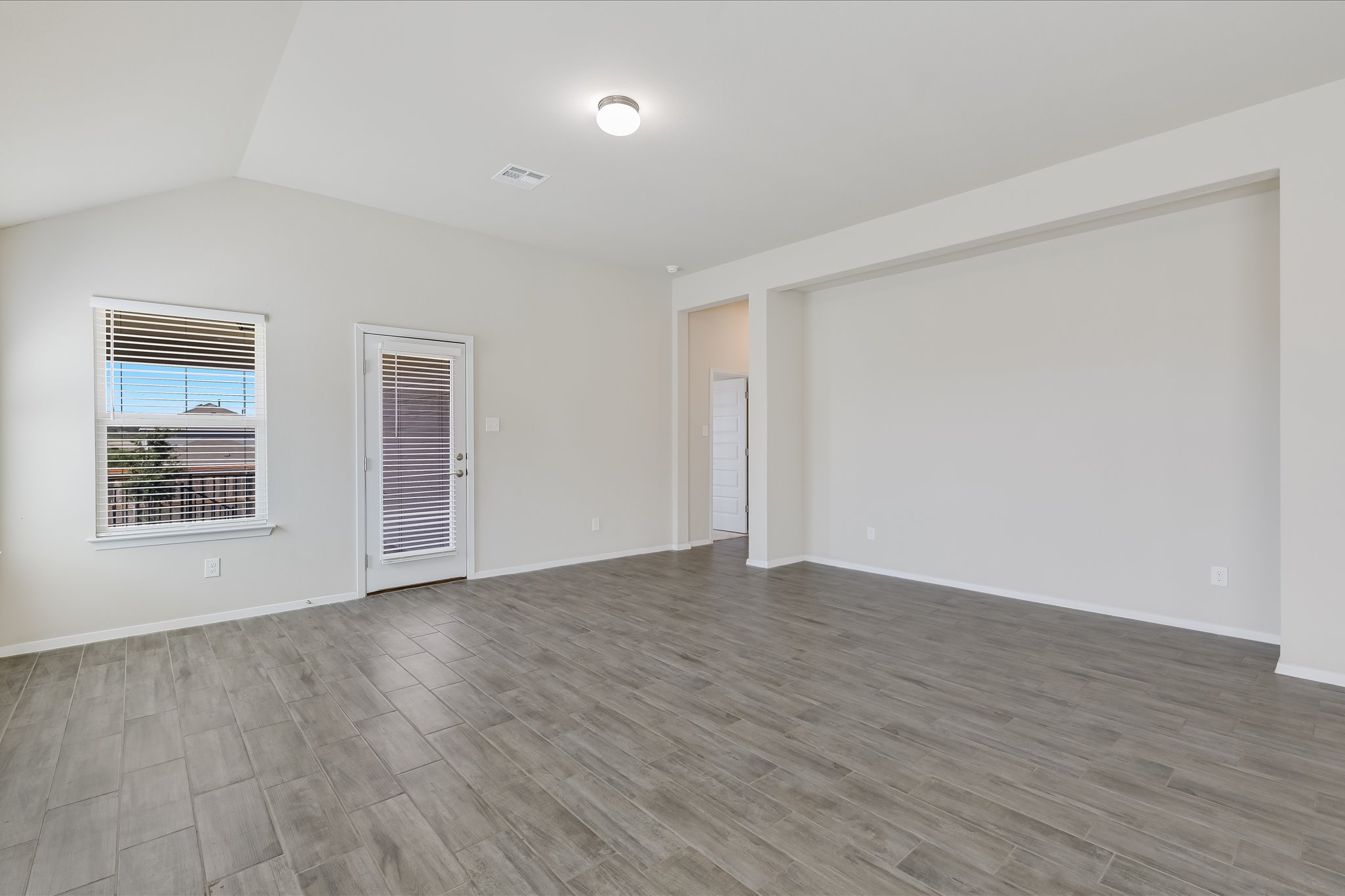 201 Spiny Lizard Lane San Marcos, TX 78666 - Photo 7 of 20 a view of an empty room with wooden floor and a window