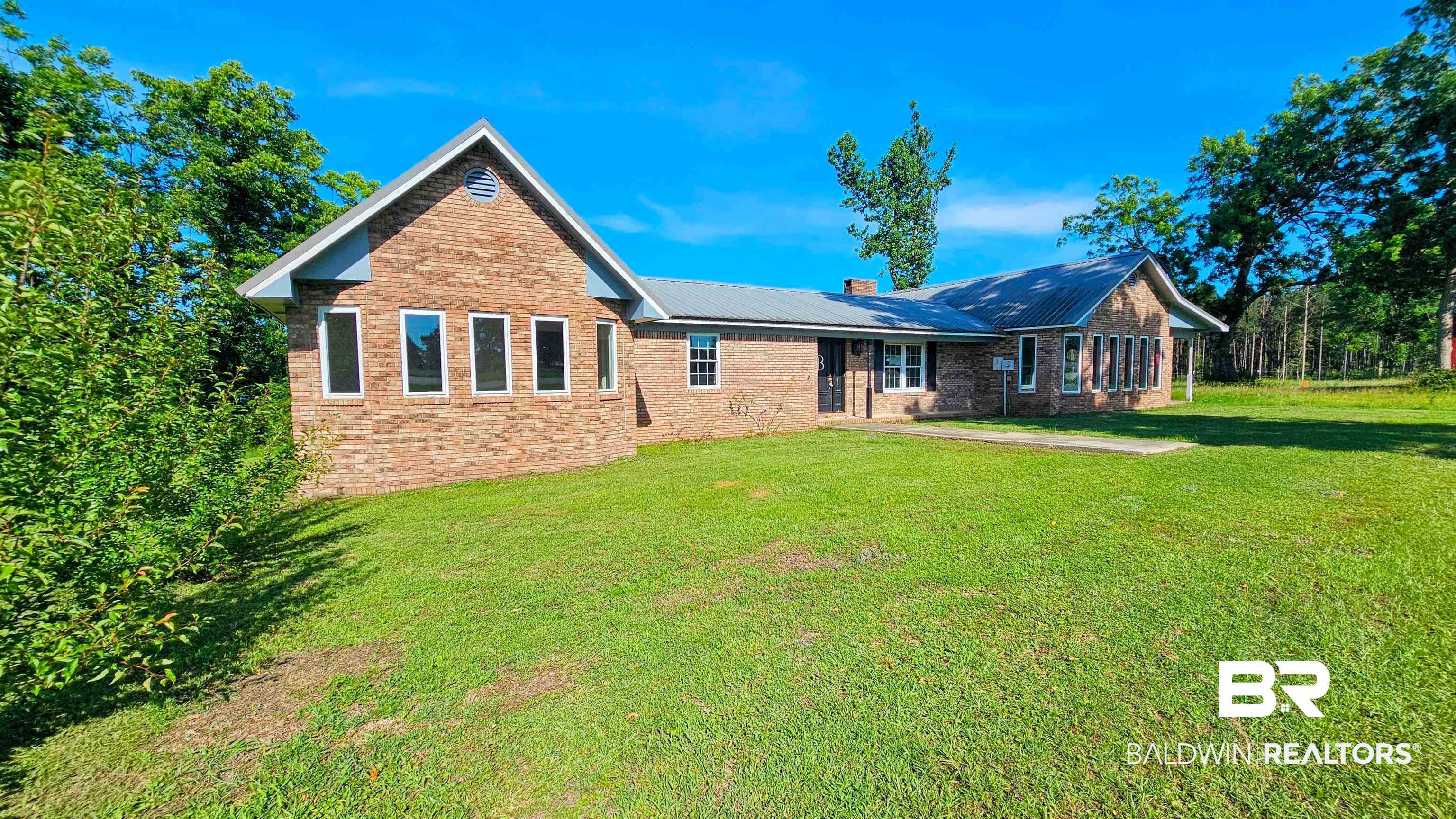 18824 Highway 41 Brewton, AL 36426 - Photo 2 of 40 Brick exterior with a metal roof and a spacious front lawn