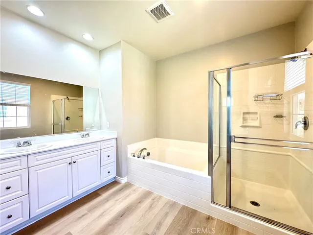 a spacious bathroom with a tub sink shower and mirror