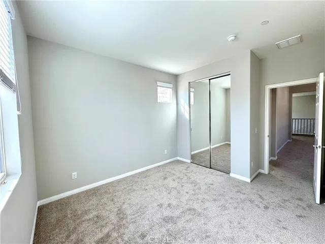 an empty room with closet and windows