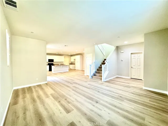 a view of a livingroom with wooden floor and a ceiling fan