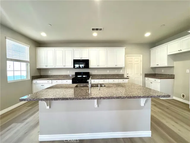 a view of a kitchen with kitchen island a window a counter space and stainless steel appliances