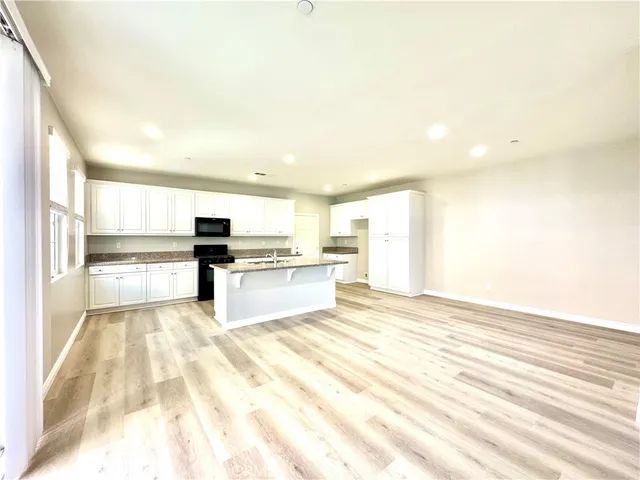 a view of kitchen with granite countertop cabinets and refrigerator