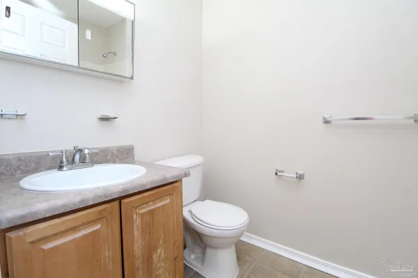 a bathroom with a granite countertop toilet sink and mirror