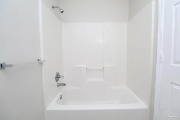a white bath tub sitting next to a white sink and vanity