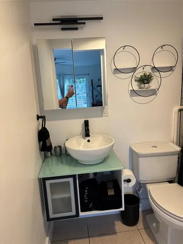 a bathroom with a toilet a sink and mirror