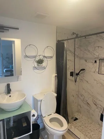 a bathroom with a toilet a sink and shower