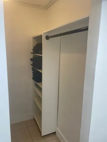 a view of walk in closet with empty racks