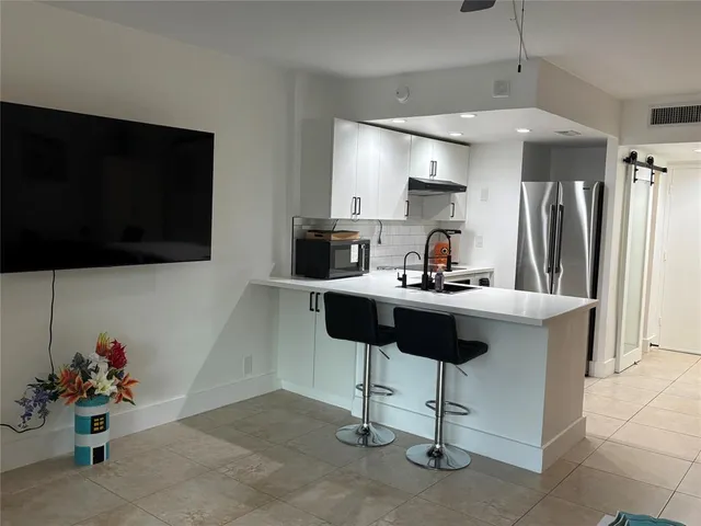 a kitchen with a refrigerator and a coffee table