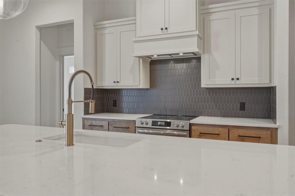 421 Red Bud Lane Tolar, TX 76476 - Photo 12 of 40 a kitchen with stainless steel appliances granite countertop a refrigerator and white cabinets