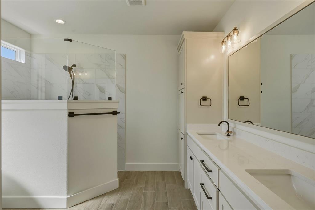 421 Red Bud Lane Tolar, TX 76476 - Photo 22 of 40 a bathroom with a double vanity sink a mirror and a shower