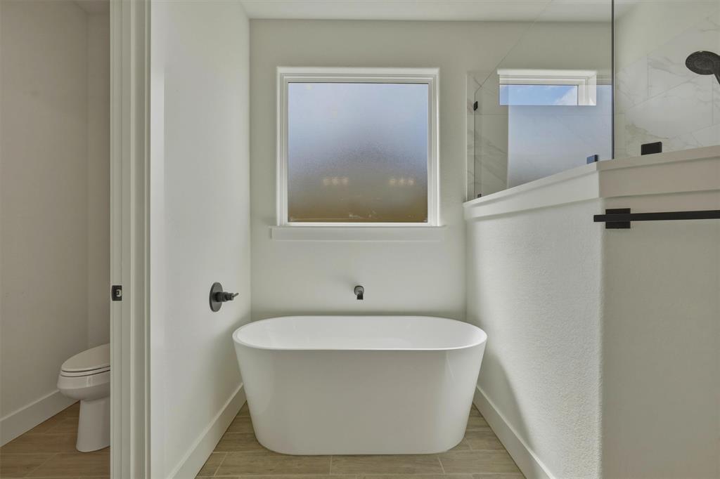 421 Red Bud Lane Tolar, TX 76476 - Photo 26 of 40 a bathroom with a white tub shower and toilet
