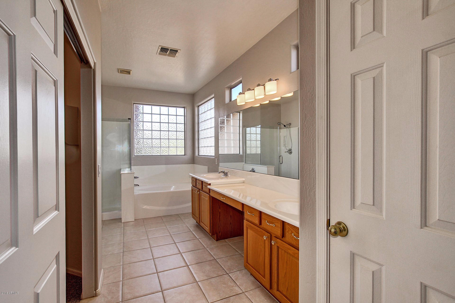 1360 East Harrison Street Gilbert, AZ 85295 - Photo 22 of 34 a large bathroom with a double vanity sink a toilet a mirror and bathtub