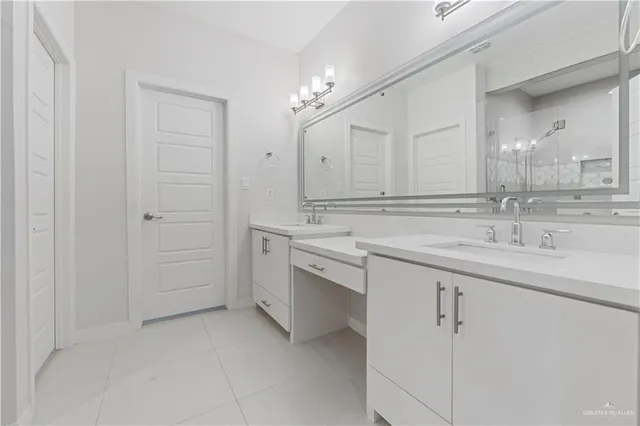 a spacious bathroom with a shower sink and mirror