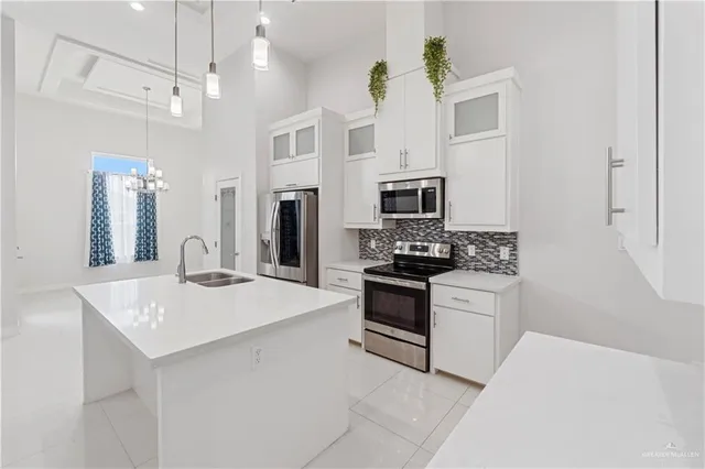 a kitchen with stainless steel appliances kitchen island granite countertop a refrigerator oven a sink dishwasher and white cabinets with wooden floor