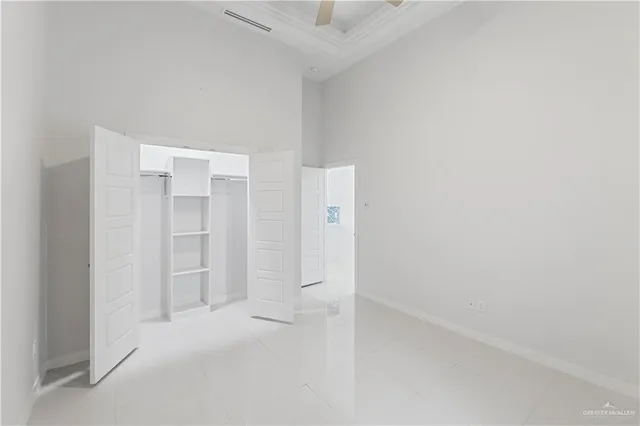 an empty room with a ceiling fan and window