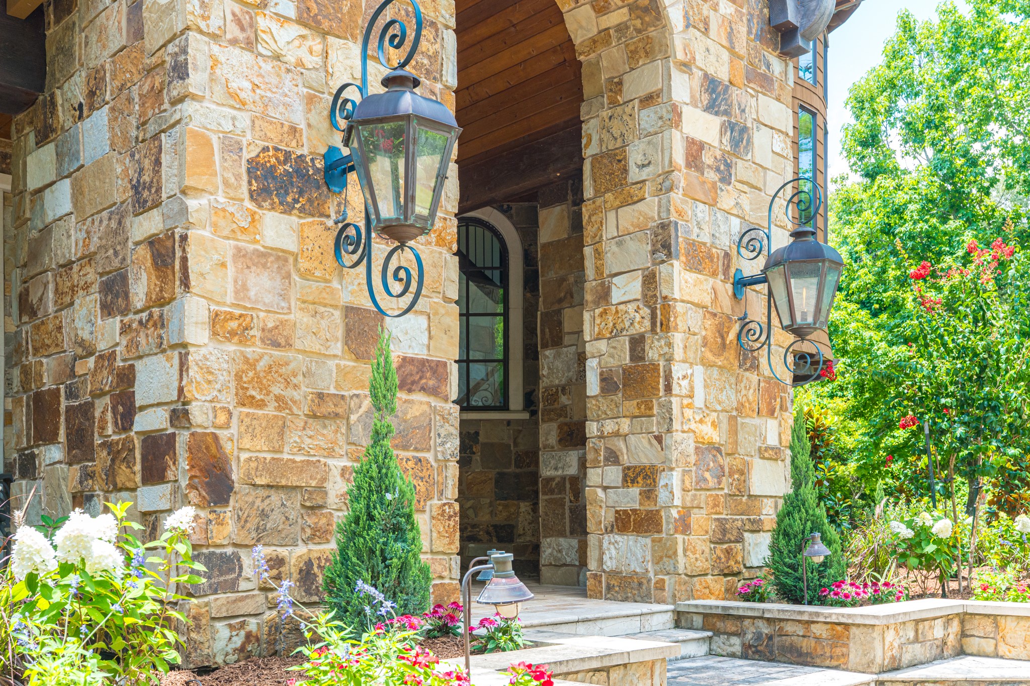 247 South Fazio Way Spring, TX 77389 - Photo 9 of 17 Timeless stone architecture, custom iron lanterns, and beautifully curated landscaping create a warm and elegant welcome, showcasing the exceptional attention to detail found throughout the home.
