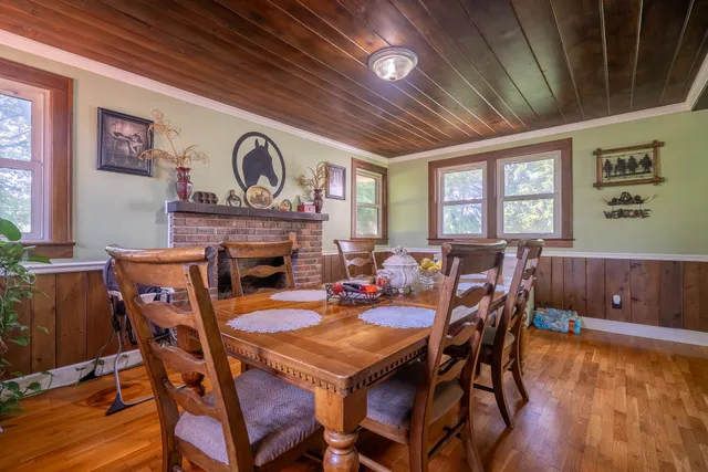 a dining room with furniture a fireplace and wooden floor