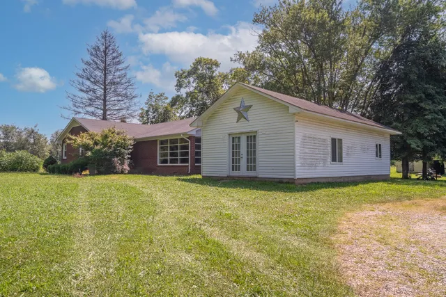 a backyard of a house with plants and outdoor seating