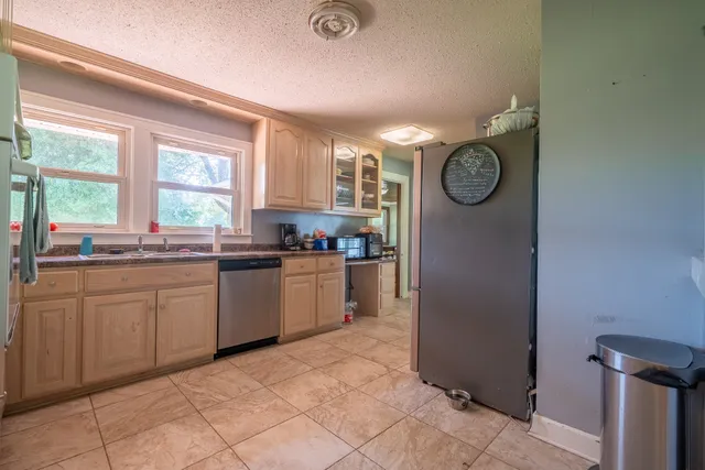 a kitchen with a refrigerator and windows