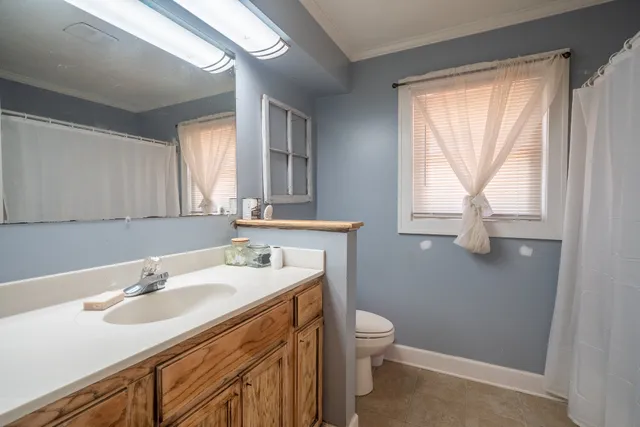 a bathroom with a sink toilet a mirror and window