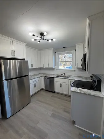a kitchen with a refrigerator sink and cabinets