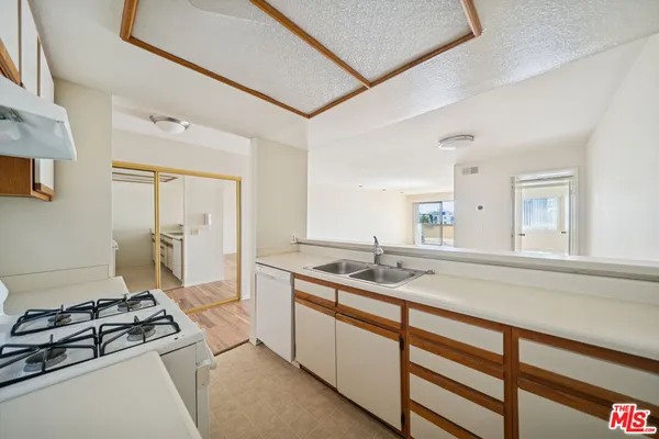 a kitchen with sink stove and cabinets