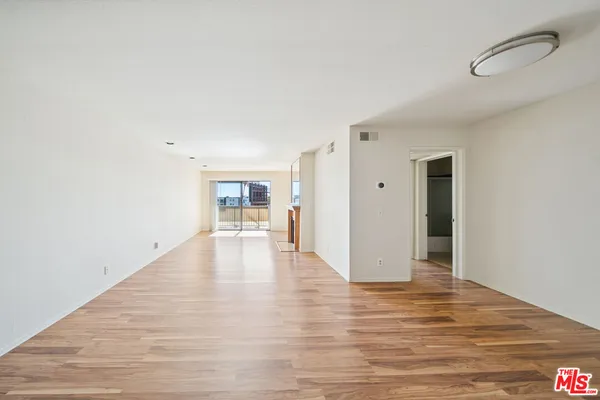 a view of a kitchen with wooden floor and a ceiling fan