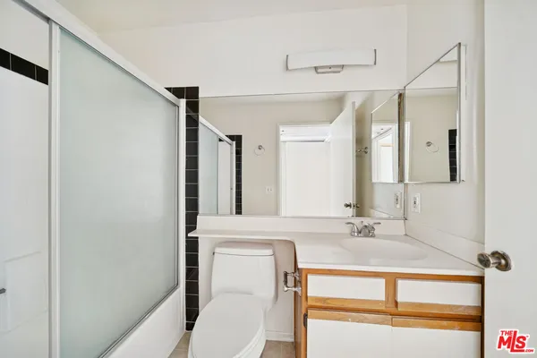 a view of a hallway with wooden floor and a room