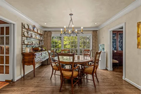 a dining room with furniture a chandelier and wooden floor