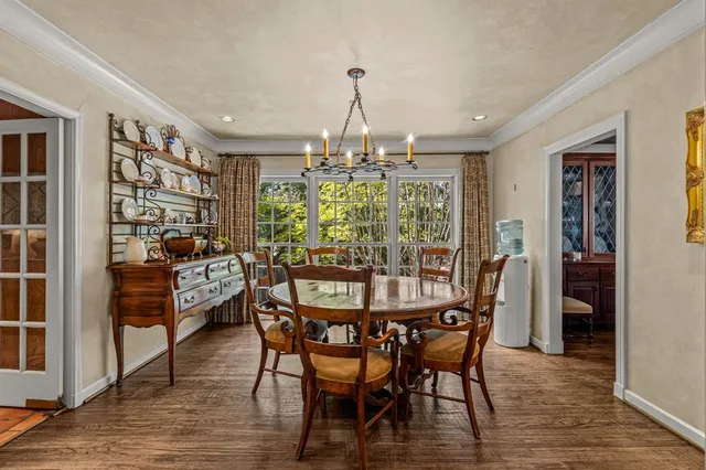 a dining room with furniture a chandelier and wooden floor