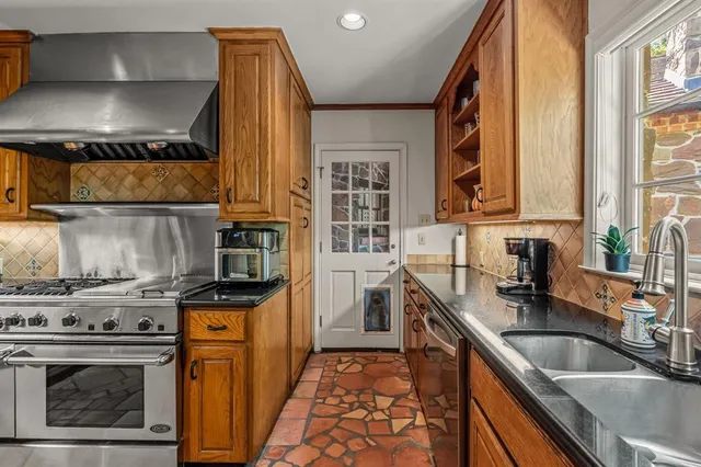 a kitchen with stainless steel appliances granite countertop a sink stove and refrigerator