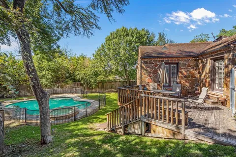 a view of a yard with plants and a bench