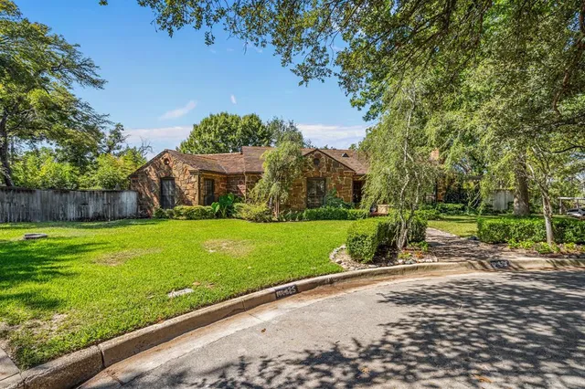 a view of an house with backyard and a tree