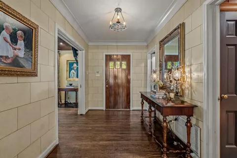 a view of a hallway with wooden floor and a livingroom